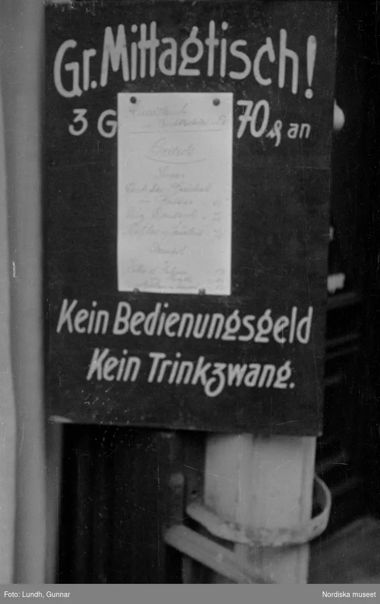 Motiv: Tyskland, Rankestrasse, Berlin, fröken Andersson, fru Rydelius;
Porträtt av två kvinnor som går på en stadsgata, en kvinna med svarta glasögon sitter i en port, stadsvy med fotgängare och en spårvagn.

Motiv: Tyskland, Berlin bl. a. Fredrichstrasse;
Skyltfönster med text "Gr. Mittagtisch! Kein Bedienungsgeld Kein Trinkzwang" och ett plakat uppsatt på fönstret, stadsvy med fotgängare och bilar, skyltfönster med text "Grog von Rum ....." "Fernsprechen", skyltfönster med text "Mittag u. Abend Gedeck 50" "Hier essen Sie besser und billiger" "Speise - Restaurant", skyltfönster med text "Gedecke bis 7 Uhr Abends 3 Gänge - 50 Grosse Auswahl."