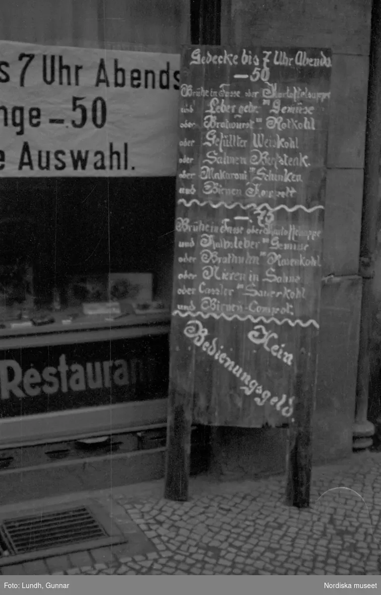 Motiv: Tyskland, Rankestrasse, Berlin, fröken Andersson, fru Rydelius;
Porträtt av två kvinnor som går på en stadsgata, en kvinna med svarta glasögon sitter i en port, stadsvy med fotgängare och en spårvagn.

Motiv: Tyskland, Berlin bl. a. Fredrichstrasse;
Skyltfönster med text "Gr. Mittagtisch! Kein Bedienungsgeld Kein Trinkzwang" och ett plakat uppsatt på fönstret, stadsvy med fotgängare och bilar, skyltfönster med text "Grog von Rum ....." "Fernsprechen", skyltfönster med text "Mittag u. Abend Gedeck 50" "Hier essen Sie besser und billiger" "Speise - Restaurant", skyltfönster med text "Gedecke bis 7 Uhr Abends 3 Gänge - 50 Grosse Auswahl."