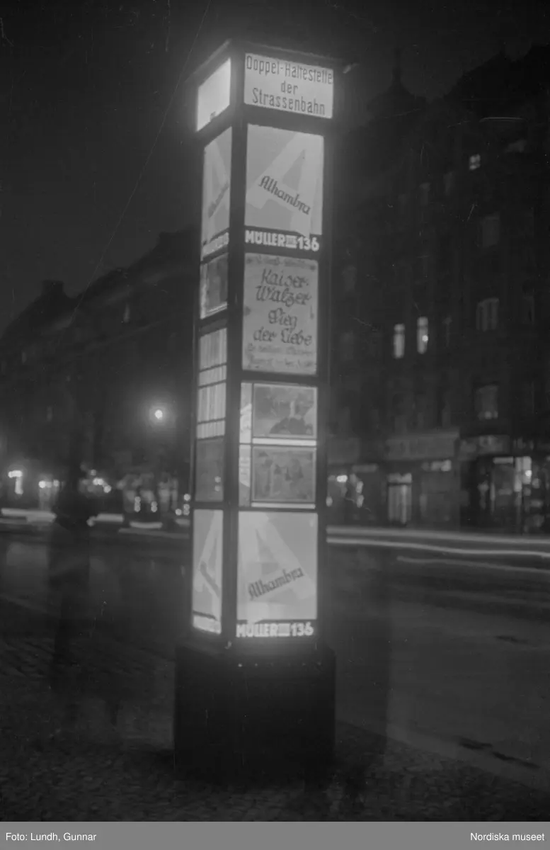 Motiv: Tyskland, Vorwärts, Reinickendorf;
Skylt "Grenzallee (Neukölln) Nach Tempelhof ....", två män står vid ett upplyst skyltfönster.

Motiv: Tyskland, Kurfurstendamm;
Exteriör av en kyrka, detalj av en fasad.