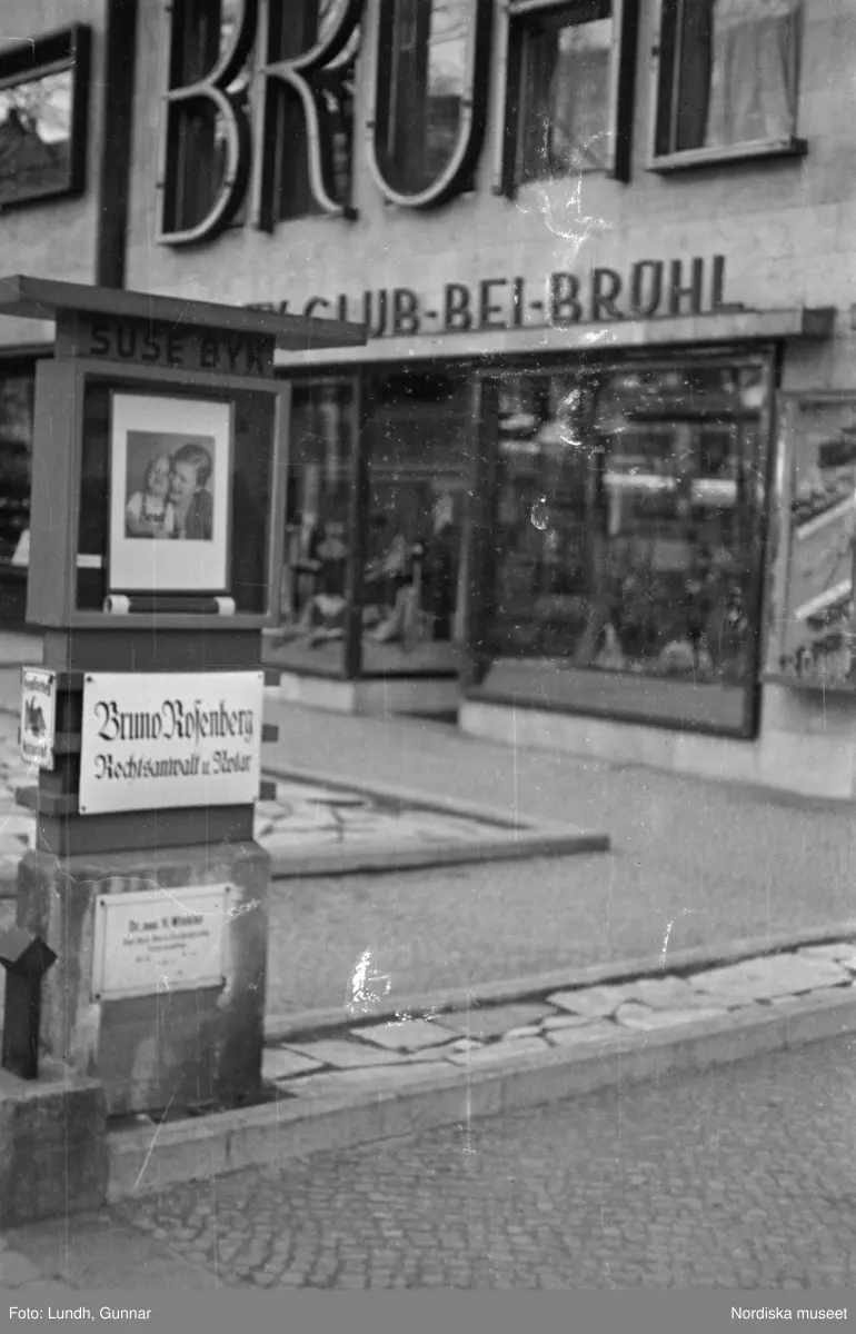 Motiv: Tyskland, Vorwärts, Reinickendorf;
Skylt "Grenzallee (Neukölln) Nach Tempelhof ....", två män står vid ett upplyst skyltfönster.

Motiv: Tyskland, Kurfurstendamm;
Exteriör av en kyrka, detalj av en fasad.