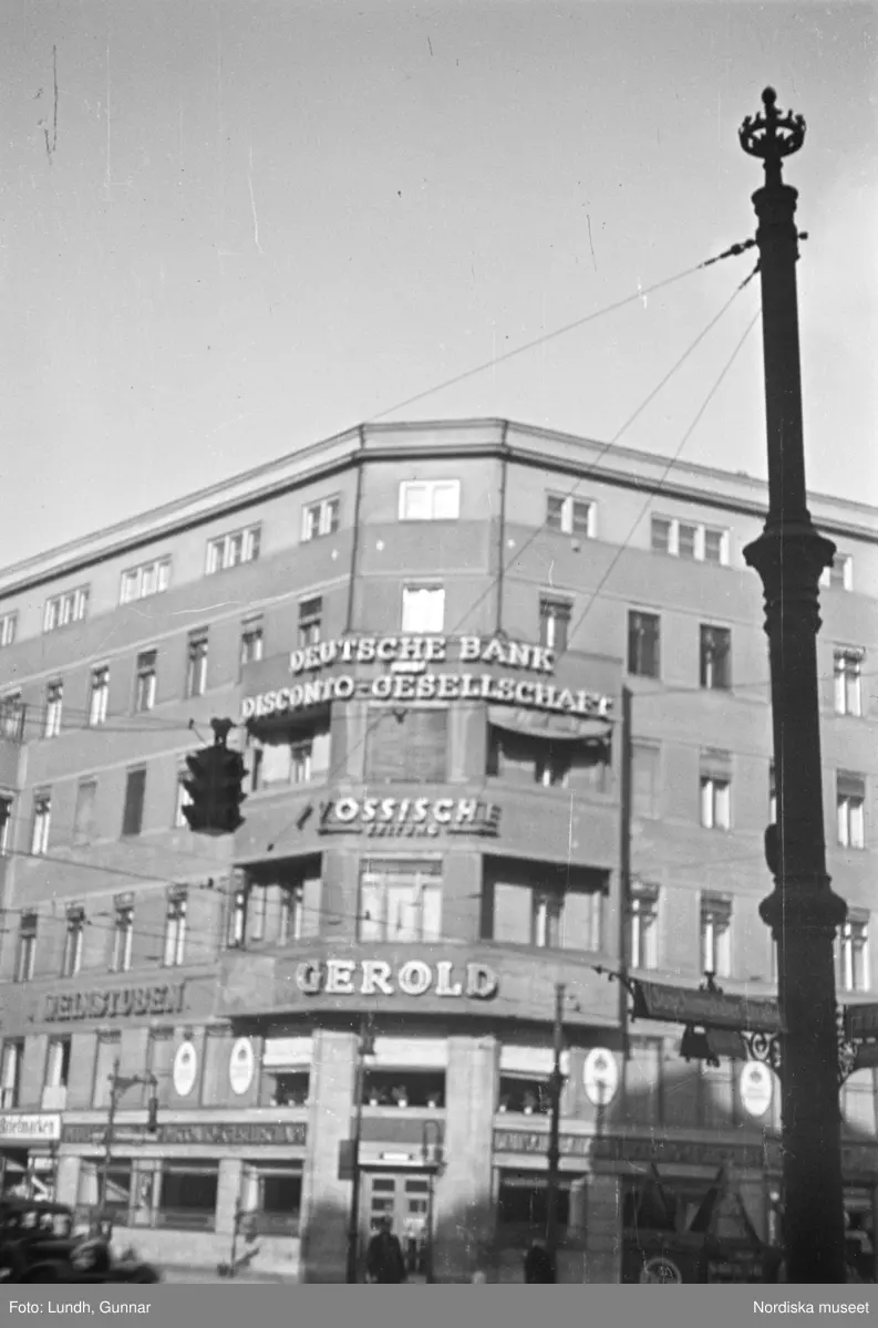 Motiv: Tyskland, Vorwärts, Reinickendorf;
Skylt "Grenzallee (Neukölln) Nach Tempelhof ....", två män står vid ett upplyst skyltfönster.

Motiv: Tyskland, Kurfurstendamm;
Exteriör av en kyrka, detalj av en fasad.