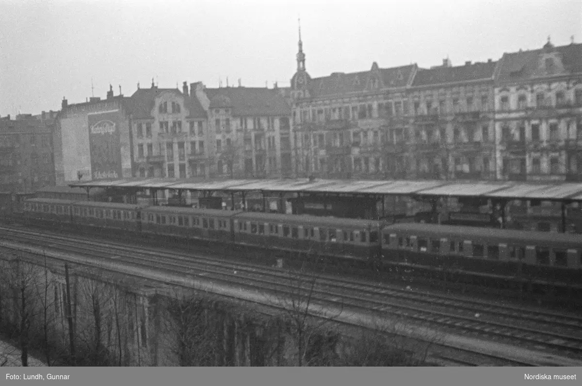 Motiv: Tyskland, Berlin, Untergrund, Friedman;
Ej kopierat.

Motiv: Tyskland, Berlin, Untergrund, Potsdamer-strasse, Potsdamer-platz;
Skylt "Pension 2 Etagen...", skyltfönster med två skyltdockor, en regnvåt gata, skylt "Zoolog. Garten", en man i fez håller upp en kanna och en kopp "Mocca Efti", skylt "Stimmüng" med en kvinna och en man som dricker cocktails, kvällsbild med belysning.