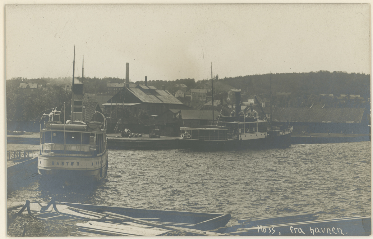 Mossesundet. Alphabrygga. Bastøferger. Postkort.

Fotograf har stått på tomta til Otto Svae.
Detaljer:	D/S Bastø II, D/S Alpha, Tollbodbrygga, Alphabrygga, industri.
Historikk: Richard Momme Peterson solgte Bastø II til A/S Alpha i 1910. På bildet ser vi fargene til Peterson.
Tekst på bildet: "Moss, fra havnen". 