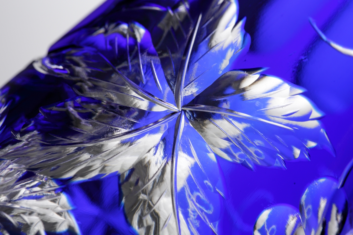 Karaff med blått överfång. Slipad dekor med vinrankor samt facettslipade partier.