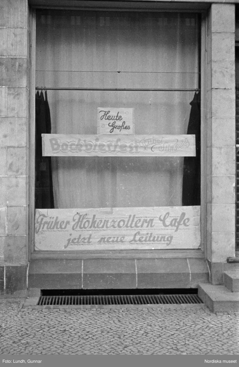 Motiv: Tyskland, Berlin;
Porträtt av en man "Tiller" som dricker ur ett glas.

Motiv: Tyskland, Berlin;
Utsikt från ett restaurangfönster över ett torg med torghandel, en man står vid ett försäljningsstånd med skylt "Sie husten nicht mehr!.....", gatuvy med en cyklist och en bil, gatuvy med bilar och en man som skjuter en kärra med text "G. Pabst Lack-Fabrik", skylt "Diese Villen sind im ganzen oder geteilt zu vermieten.....", grind med skyltar "Prof. Georg Klempener" "Professor Dr. A. Pinkuss", gatuvy med an man som samtalar med en kvinna, ett bord på gatan med böcker till försäljning, skylt "5 zimmer wohnung 1 etage auch geteilt per 1. april näheres b. wirt.", exteriör av byggnad med stor skylt på fasaden "Zu vermieten....", gatuvy med bilar - spårvagn - man med handkärra och en man som sopar gatan.