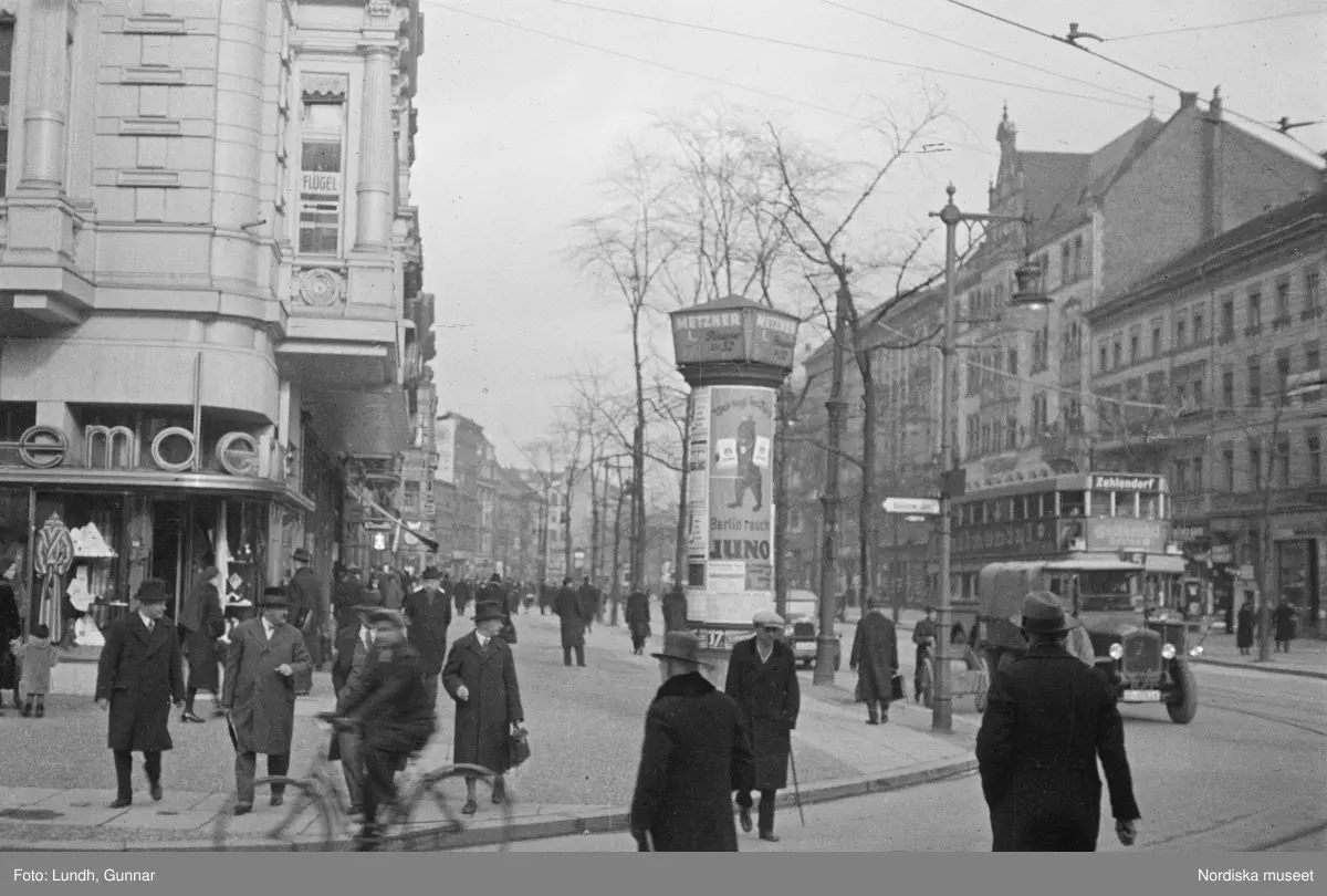 Motiv: Tyskland, Berlin;
Porträtt av en man "Tiller" som dricker ur ett glas.

Motiv: Tyskland, Berlin;
Utsikt från ett restaurangfönster över ett torg med torghandel, en man står vid ett försäljningsstånd med skylt "Sie husten nicht mehr!.....", gatuvy med en cyklist och en bil, gatuvy med bilar och en man som skjuter en kärra med text "G. Pabst Lack-Fabrik", skylt "Diese Villen sind im ganzen oder geteilt zu vermieten.....", grind med skyltar "Prof. Georg Klempener" "Professor Dr. A. Pinkuss", gatuvy med an man som samtalar med en kvinna, ett bord på gatan med böcker till försäljning, skylt "5 zimmer wohnung 1 etage auch geteilt per 1. april näheres b. wirt.", exteriör av byggnad med stor skylt på fasaden "Zu vermieten....", gatuvy med bilar - spårvagn - man med handkärra och en man som sopar gatan.