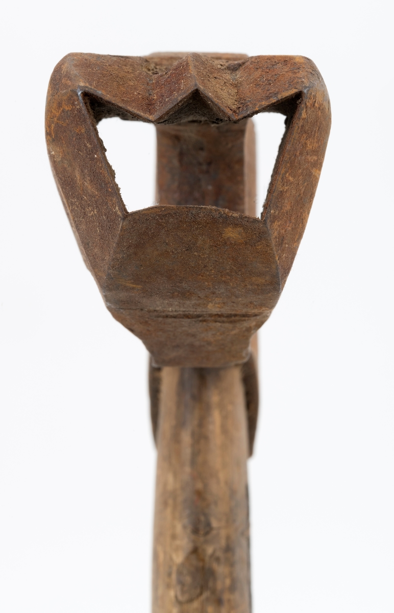 Øks - brukt til merking av fløtingstømmer i målings- og annammingsprosessen som foregikk langs vassdragene i overgangsfasen mellom vinter og vår, da tømmerstokkene etter måling formelt skiftet eier - fra skogeieren som hadde organisert hogst og framkjøring til sagbruk eller treforedlingsbedrift, som kjøpte tømmeret med sikte på videre bearbeiding til produkter som var salgbare på et større marked. 

Øksehodet (den smidde delen) er 14,2 centimeter høyt fra eggpartiet til nakken. Nakkedelen er 7,9 centimeter lang, 2,5 centimeter bred bakerst og 2,3 centimeter bred foran. Øksenakken er noenlunde plan i lengderetningen. På venstre side av den nedre delen av øksehodet (bladet) er det utsmidd en 3,5 centimeter høy «sko» med profilert, fasslipt egg. Denne eggen ble slått inn i yteveden på fløtingsvirket, der den etterlot seg en profilert forsenkning, et symbol som tjente som sorteringsgrunnlag ved lenseanleggene i den nedre delen av vassdraget. På denne øksa minner eggprofilen om omrisset av ei krone. På høyre side av øksehodet finner vi smedstempelet «K. KNUDSEN  MJØNDALEN» samt avbildninger av medaljer denne produsenten hadde oppnådd på utstillinger. Øksehodet er rustent og stempelet er vanskelig lesbart.

Denne øksa har et cirka 60 centimeter langt, noenlunde rett treskaft. Som økseskaft flest er det bredest i høyderetningen og smalest i bredderetningen i den fremre enden, der den er skjeftet. Den bakre delen av skaftet er mer rundoval. Den fremre skaftenden er kilet med en trekile som skulle redusere faren for at øksa løsnet fra skaftet under merkingsarbeidet. Det forkortete firmanavnet «KELL-PARTINGTON» er påført den venstre sida av skaftet (sett i øksebrukerens perspektiv) ved hjelp av svijernstempel. Dette indikerer at øksa har vært brukt til å merke tømmer som ble innkjøpt på vegne av The Kellner Partington Paper Pulp Co. Lim., et engelsk selskap som fram til 1918 eide Borregaard-fabrikken i Sarpsborg. Navnet fortsatte å figurere på merkekartene også etter at Borregaard fikk norsk eierskap, jfr. «Merkekart 1953 for Glommen» i Julius Nygaards skogalmanakk 1954. 

Litt generell informasjon om bruken av merkeøkser i skogbruket finnes under fanen «Opplysninger».