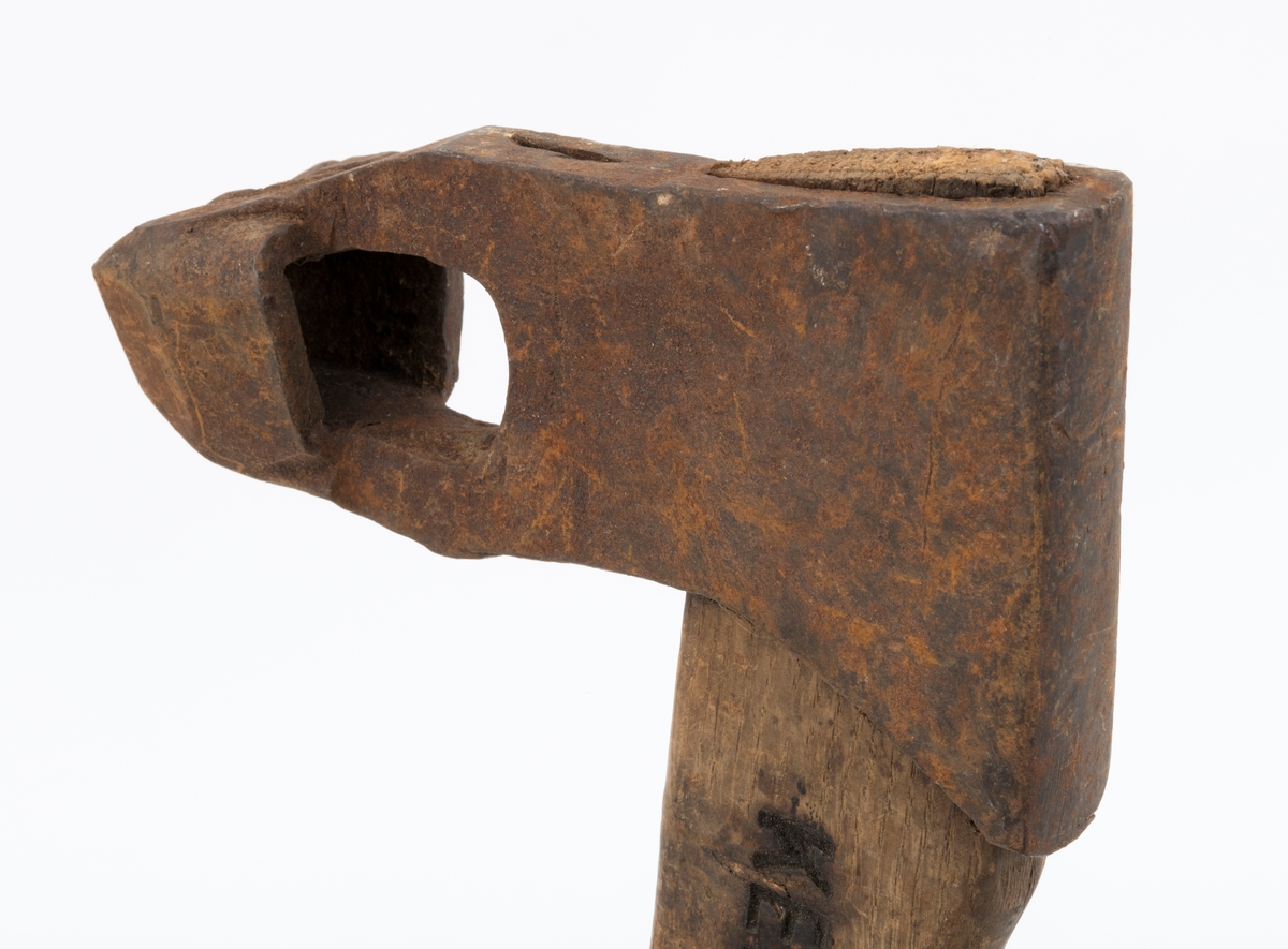 Øks - brukt til merking av fløtingstømmer i målings- og annammingsprosessen som foregikk langs vassdragene i overgangsfasen mellom vinter og vår, da tømmerstokkene etter måling formelt skiftet eier - fra skogeieren som hadde organisert hogst og framkjøring til sagbruk eller treforedlingsbedrift, som kjøpte tømmeret med sikte på videre bearbeiding til produkter som var salgbare på et større marked. 

Øksehodet (den smidde delen) er 14,2 centimeter høyt fra eggpartiet til nakken. Nakkedelen er 7,9 centimeter lang, 2,5 centimeter bred bakerst og 2,3 centimeter bred foran. Øksenakken er noenlunde plan i lengderetningen. På venstre side av den nedre delen av øksehodet (bladet) er det utsmidd en 3,5 centimeter høy «sko» med profilert, fasslipt egg. Denne eggen ble slått inn i yteveden på fløtingsvirket, der den etterlot seg en profilert forsenkning, et symbol som tjente som sorteringsgrunnlag ved lenseanleggene i den nedre delen av vassdraget. På denne øksa minner eggprofilen om omrisset av ei krone. På høyre side av øksehodet finner vi smedstempelet «K. KNUDSEN  MJØNDALEN» samt avbildninger av medaljer denne produsenten hadde oppnådd på utstillinger. Øksehodet er rustent og stempelet er vanskelig lesbart.

Denne øksa har et cirka 60 centimeter langt, noenlunde rett treskaft. Som økseskaft flest er det bredest i høyderetningen og smalest i bredderetningen i den fremre enden, der den er skjeftet. Den bakre delen av skaftet er mer rundoval. Den fremre skaftenden er kilet med en trekile som skulle redusere faren for at øksa løsnet fra skaftet under merkingsarbeidet. Det forkortete firmanavnet «KELL-PARTINGTON» er påført den venstre sida av skaftet (sett i øksebrukerens perspektiv) ved hjelp av svijernstempel. Dette indikerer at øksa har vært brukt til å merke tømmer som ble innkjøpt på vegne av The Kellner Partington Paper Pulp Co. Lim., et engelsk selskap som fram til 1918 eide Borregaard-fabrikken i Sarpsborg. Navnet fortsatte å figurere på merkekartene også etter at Borregaard fikk norsk eierskap, jfr. «Merkekart 1953 for Glommen» i Julius Nygaards skogalmanakk 1954. 

Litt generell informasjon om bruken av merkeøkser i skogbruket finnes under fanen «Opplysninger».