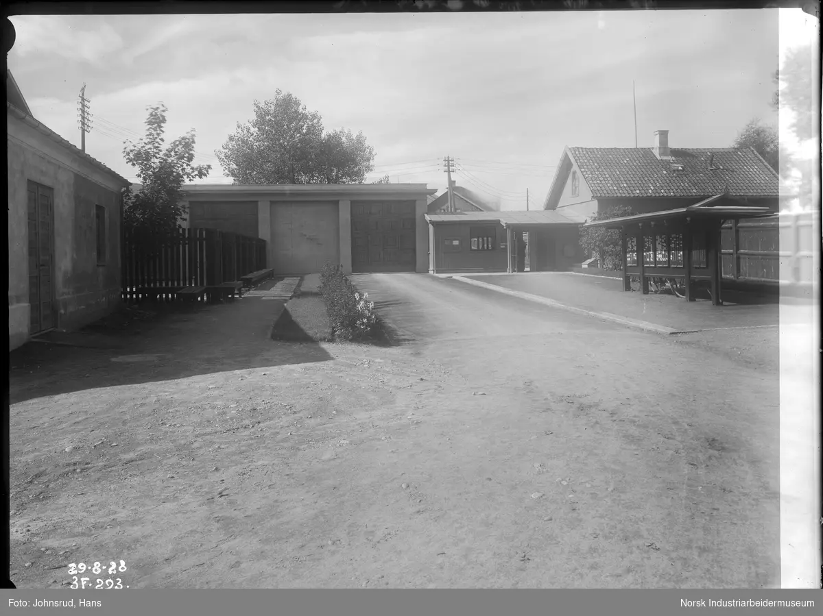 Portnerstue (portvakta) med innkjørsel (sett innenfra). Tavle for ansatt kort rett innenfor portvakta.