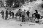 Många nyfikna har samlats när strömmingsnoten landas. Året är 1910 och fångsten landas invid Korsholmen i Sankt Anna.