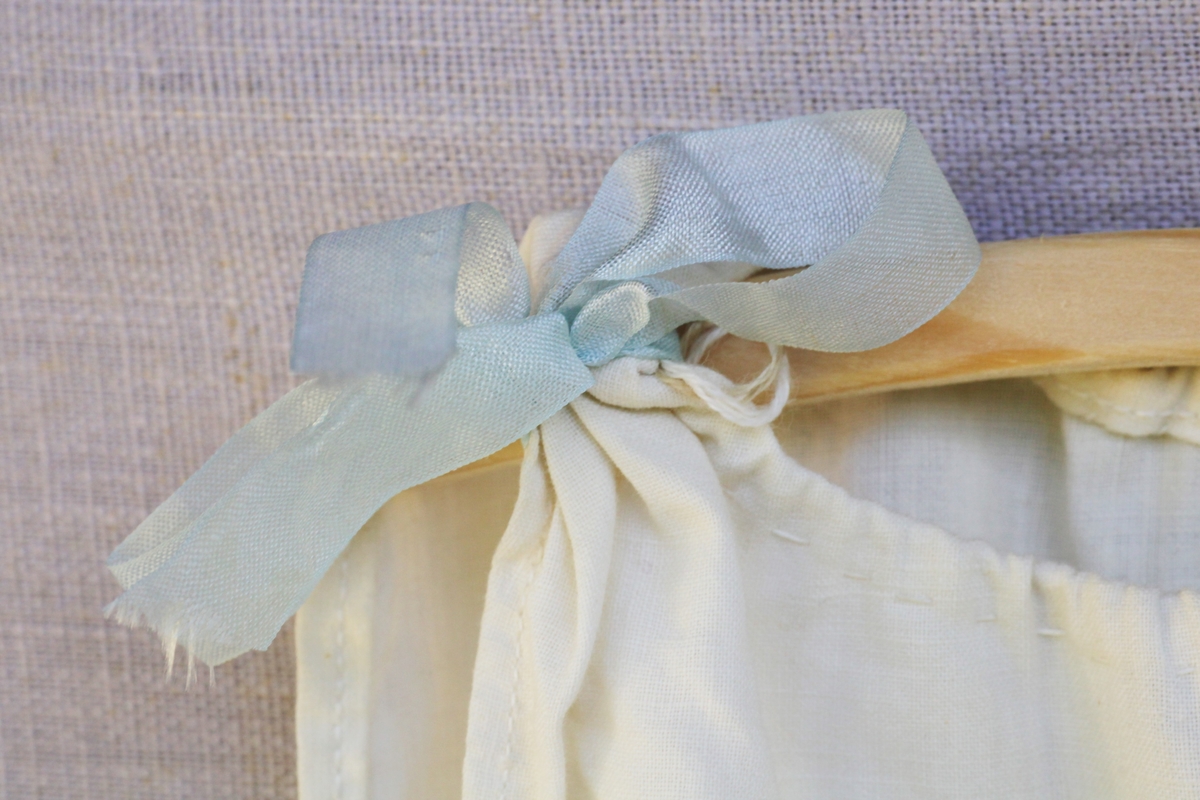 To kjoler med enkelt snitt, snøring i livet og pyntet med sløyfer på skuldrene. En blå og en lilla.