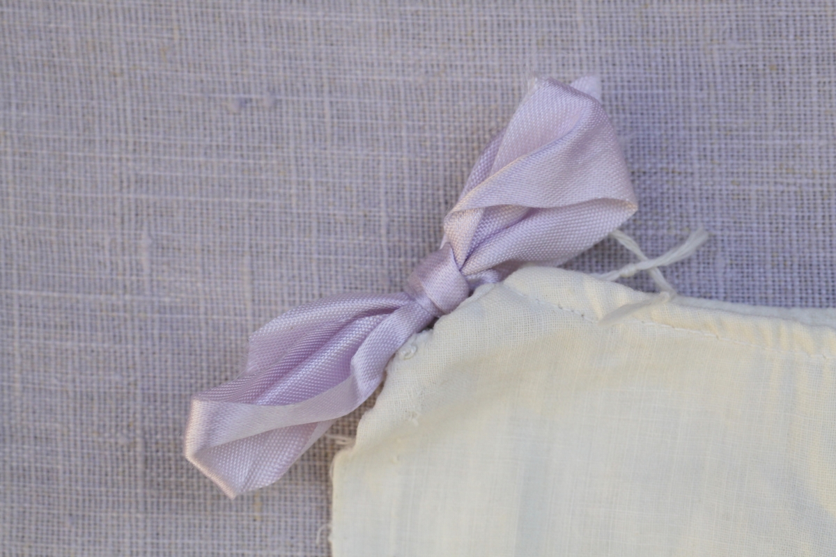 To kjoler med enkelt snitt, snøring i livet og pyntet med sløyfer på skuldrene. En blå og en lilla.