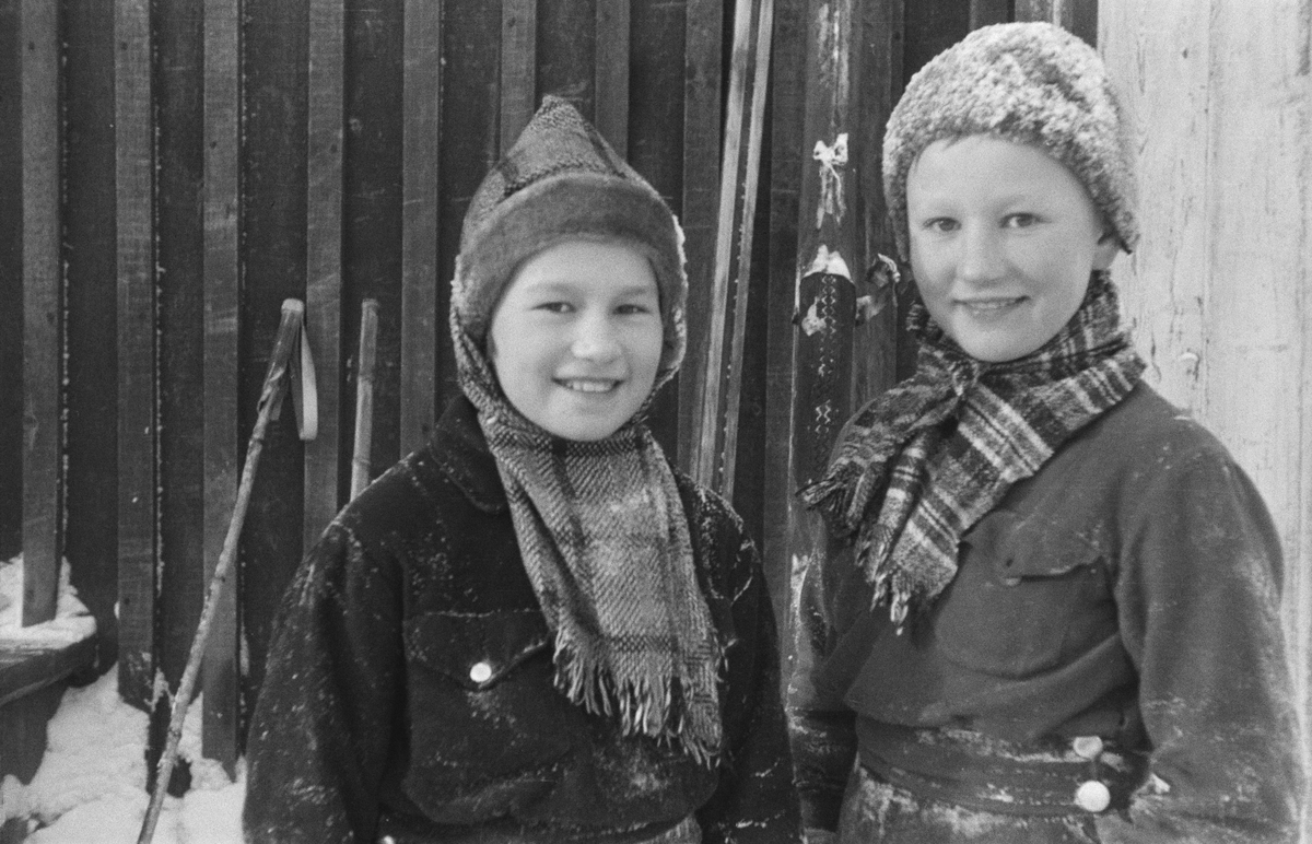 Porträttfoto av två finska pojkar utomhus under finska vinterkriget. Bild från F 19, Svenska frivilligkåren i Finland, 1940.