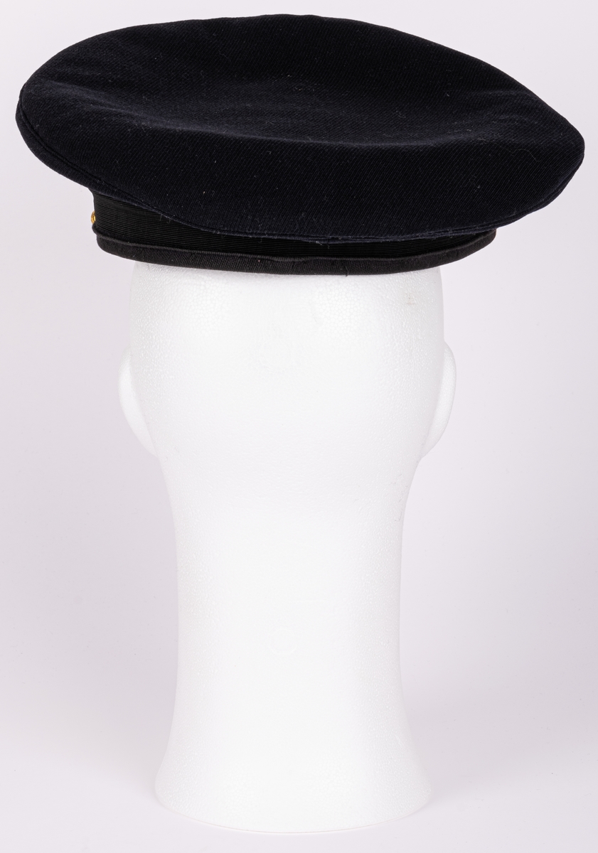 Skärmmössa m/30 för flygvapnet.
Av mörkblått ylletyg (gabardin) med svartlackerad skärm (undersidan ljusgrön). Svart textilband runt mössans nederdel. Kullen cirkelrund, platt och med större diameter. Dess styvnader är borttagna. Flygemblek av broderad guldtråd. Hakrem av flätad guldtråd (m/39), fäst med två små kronknappar. Vitt linnefoder. Svettremmen märkt "HF". etikett i kullen "KÖRSNÄR Lundbladhs HÄLSINGBORG"