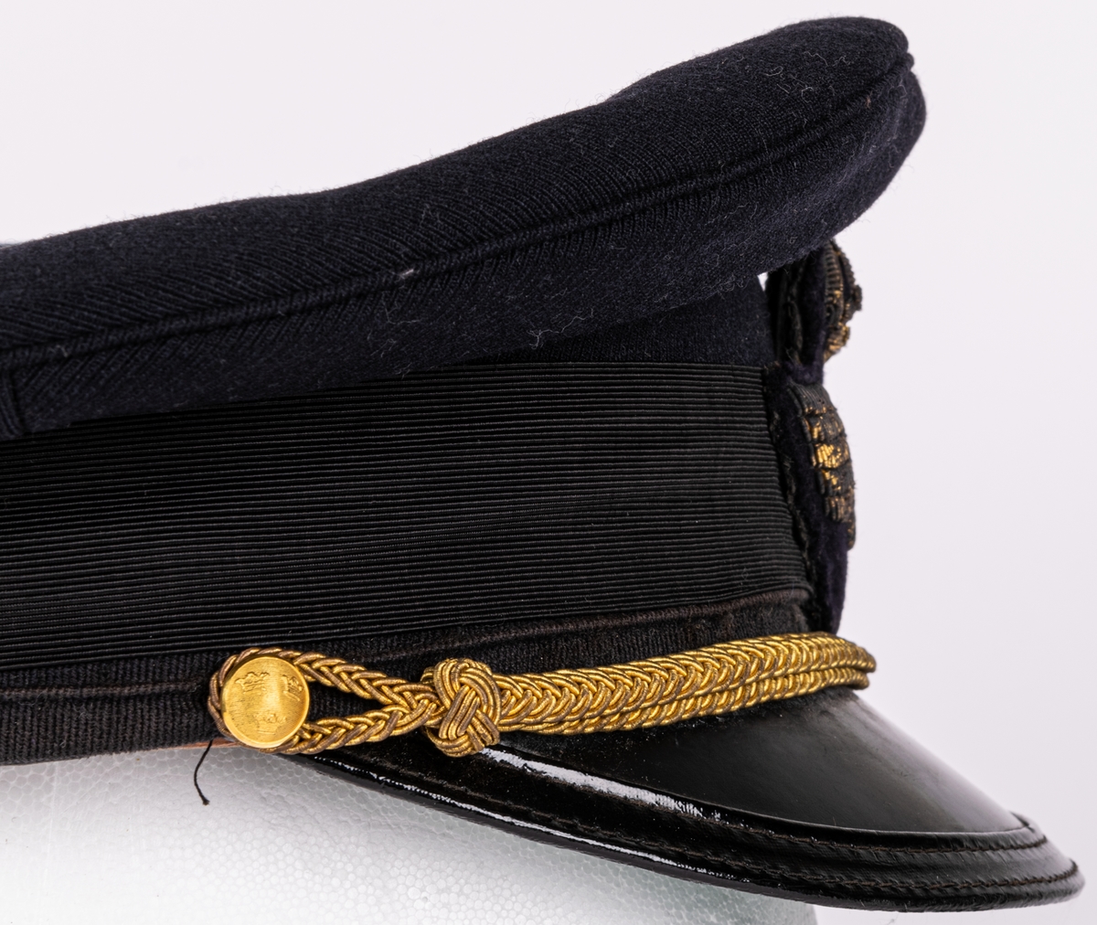 Skärmmössa m/30 för flygvapnet.
Av mörkblått ylletyg (gabardin) med svartlackerad skärm (undersidan ljusgrön). Svart textilband runt mössans nederdel. Kullen cirkelrund, platt och med större diameter. Dess styvnader är borttagna. Flygemblek av broderad guldtråd. Hakrem av flätad guldtråd (m/39), fäst med två små kronknappar. Vitt linnefoder. Svettremmen märkt "HF". etikett i kullen "KÖRSNÄR Lundbladhs HÄLSINGBORG"