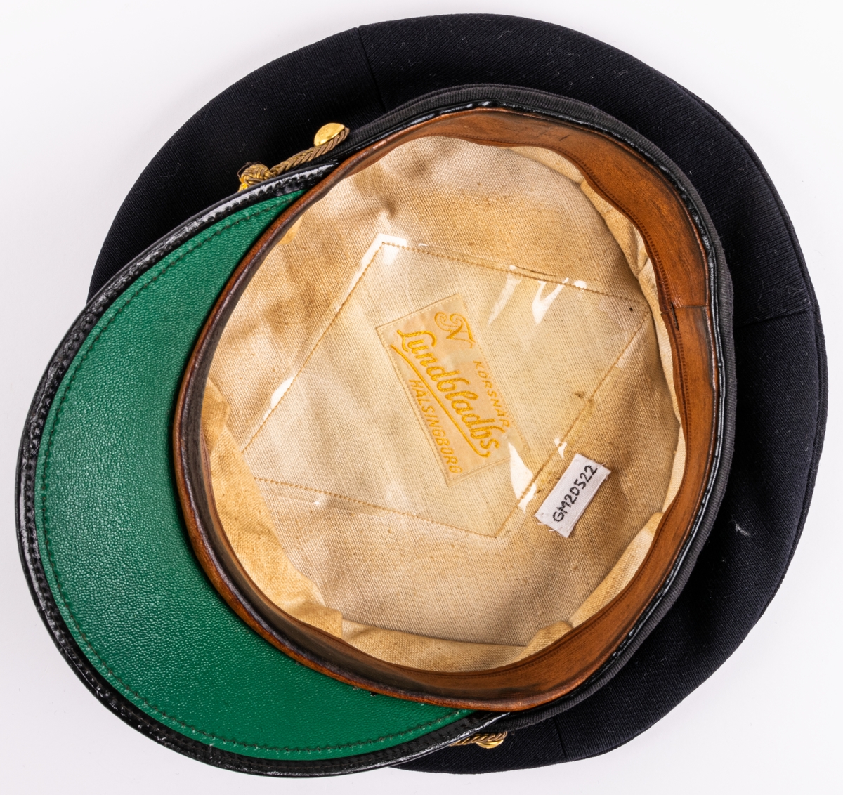 Skärmmössa m/30 för flygvapnet.
Av mörkblått ylletyg (gabardin) med svartlackerad skärm (undersidan ljusgrön). Svart textilband runt mössans nederdel. Kullen cirkelrund, platt och med större diameter. Dess styvnader är borttagna. Flygemblek av broderad guldtråd. Hakrem av flätad guldtråd (m/39), fäst med två små kronknappar. Vitt linnefoder. Svettremmen märkt "HF". etikett i kullen "KÖRSNÄR Lundbladhs HÄLSINGBORG"