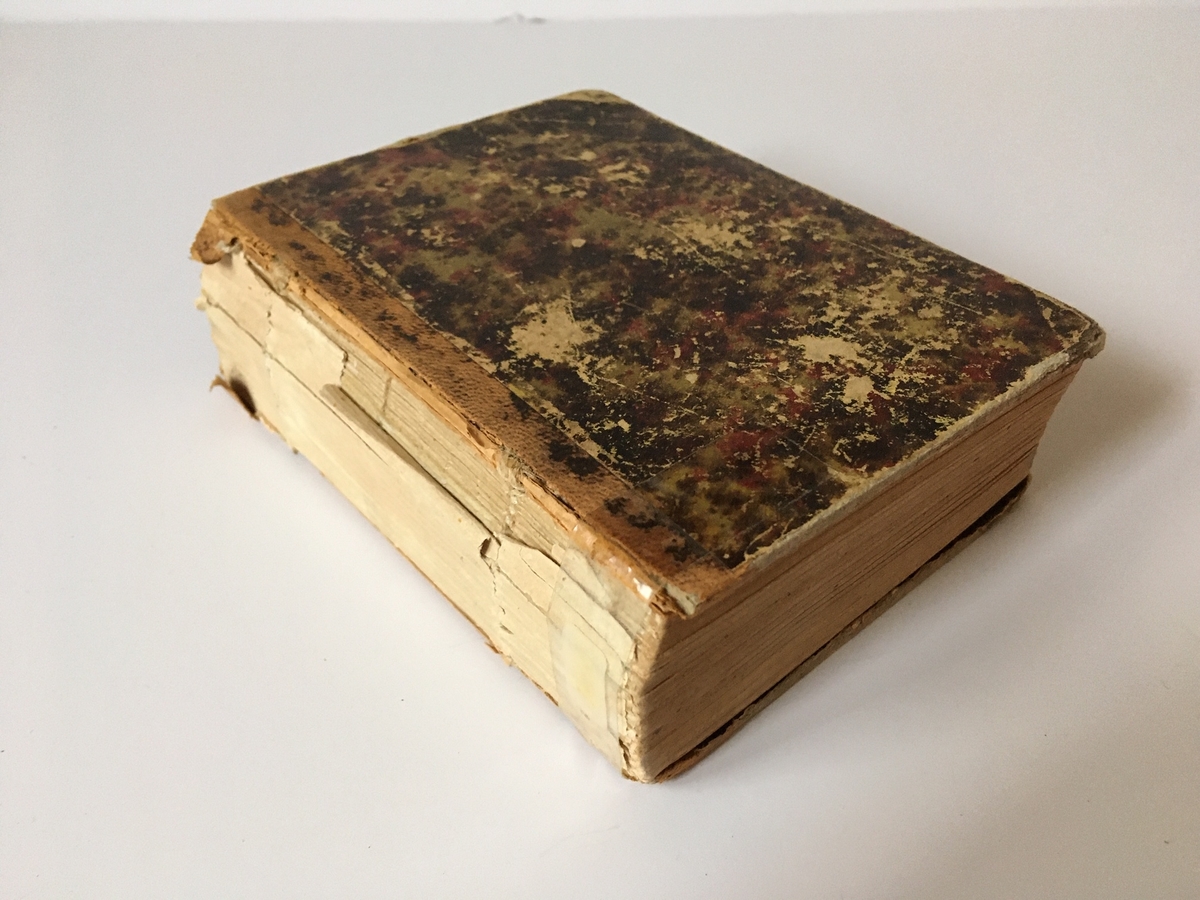 Liten bok med saknad rygg. Titelsidan: "Engelskt och Svenskt Handlexikon. 667 sidor. L. J. Hiertas förlag. Stereotypupplaga, omtryckt hos A. L. Normans i Stockholm 1874