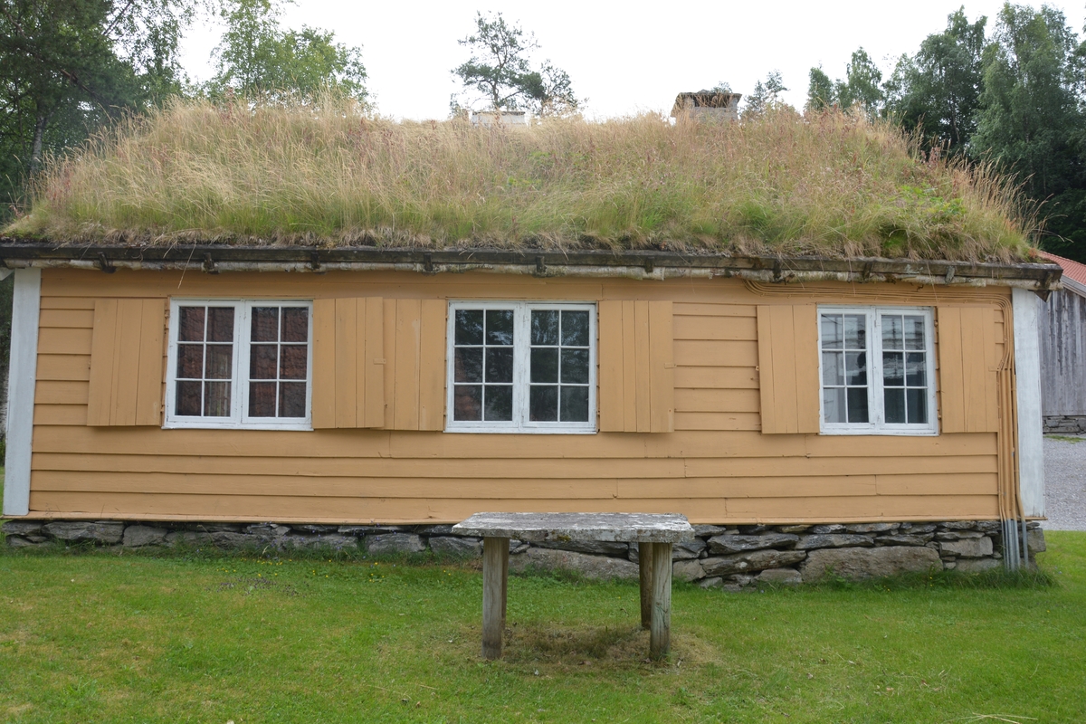 Tømra bygning med treromsplan: forstove/"Døra", skulestova og kammes. Jarnomn. Liggande panel. Torvtak.