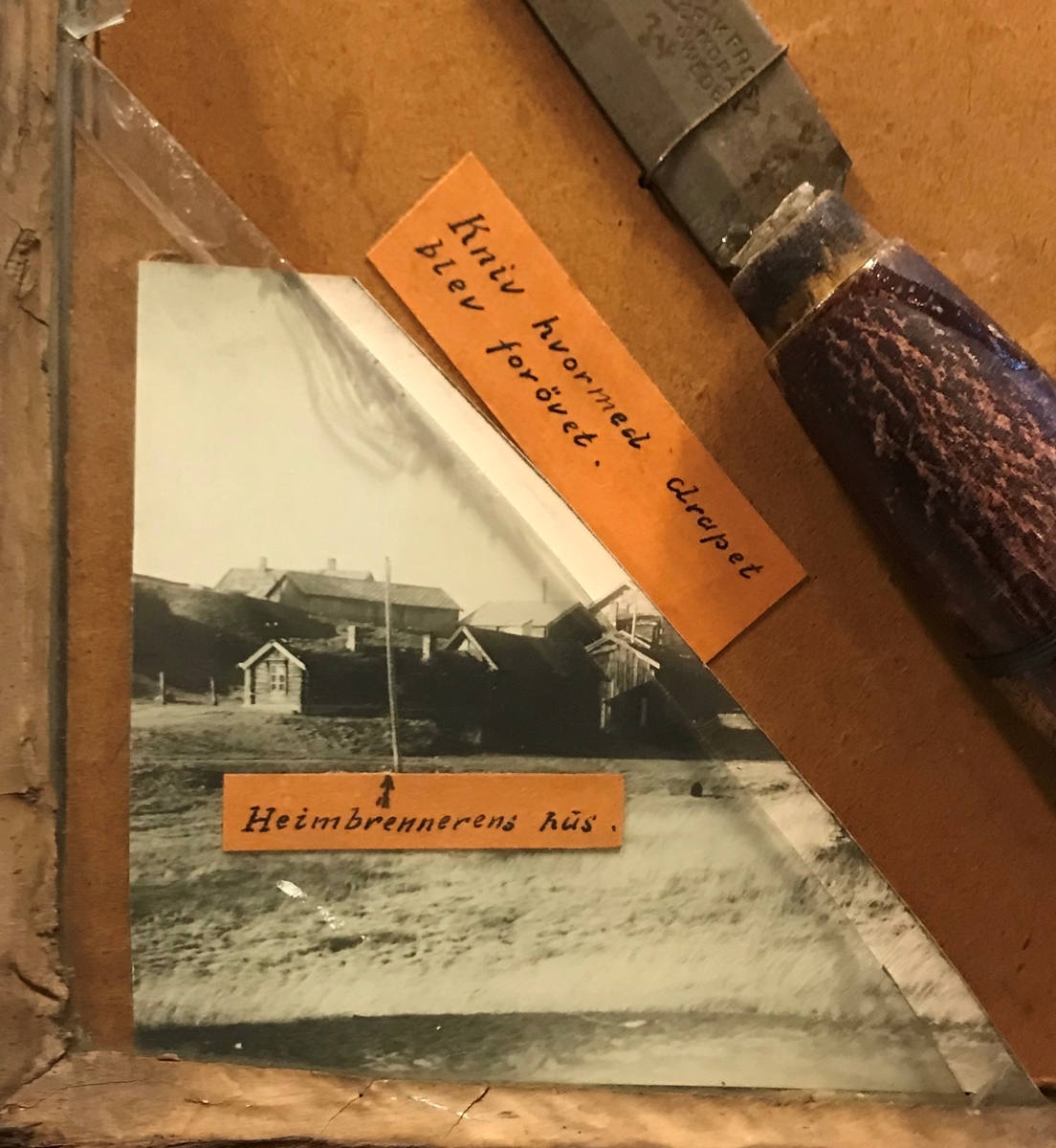 En montasje laget av bevismateriale; en knust vindusrute, et skjerf , en tollekniv der bladet er løsnet fra skaftet, to håndflateavtrykk og tre foto. Deler av montasjen er gjenbruk av et maleri.