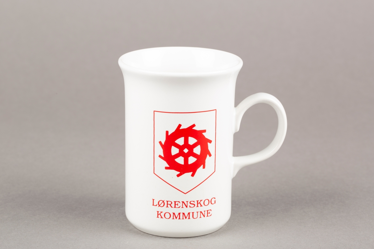 Krus med hank. Bilde av Lørenskogs kommunevåpen. Vannhjul.