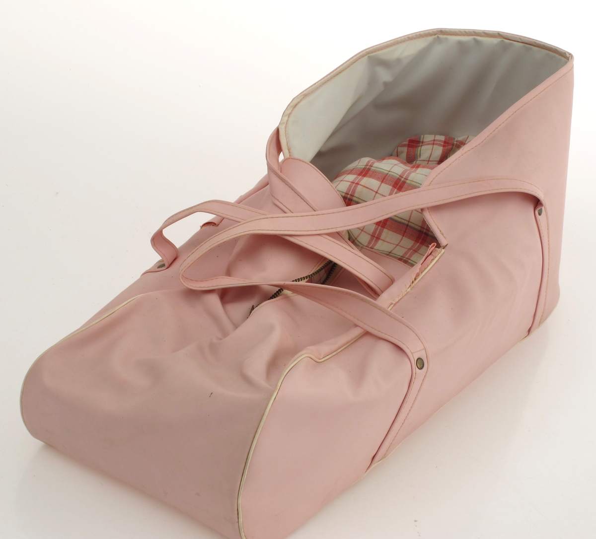 Dukke med dukkeklær, bærebag samt kuffert med flere dukkeklær. Dukken er ved innkomst kledd i sykepleieruniform. 

DELER: 
a. Dukke
Hode og hender/armer av celluloid. Resten av tekstilt materiale. 
b. Bærebag til dukke
Av plast, sky. Rosa farge med glidelås. Nyere enn dukke og kuffert. 
c. Koffert (med dukkeklær ved innkomst) 
Kuffert av tykk kartong. Sydd sammen. Lærhempe til hengsler. Handtak festet med metallbeslag. 
d - z  Dukkeklær