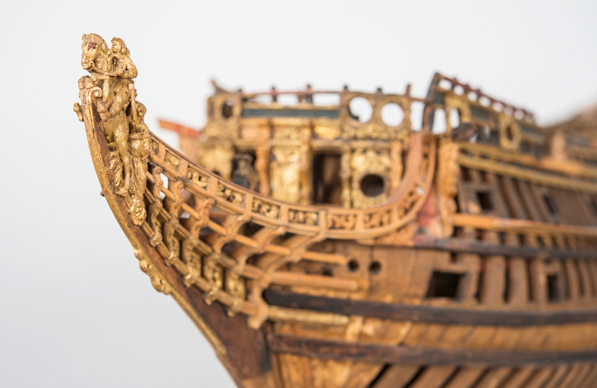 This unplanked model of a three-decker can be dated to c. 1660 and is one of the world's oldest models of a warship. Although not definitively identified, recent research links it to the Swedish ship *Riksäpplet*, designed by the English master shipwright Francis Sheldon and launched in 1661.     
The model was possibly made for Sheldon, who came to Sweden in 1659. He was one of a number of English shipwrights employed by the Swedish crown during the period. Previously, most Swedish warships had been built in the Dutch style.

From around 1660, the English Royal Navy’s administrators commissioned models that were accurately detailed and true to scale. These miniatures, which came to be called Navy or Admiralty Board models, had an unplanked lower hull to emphasise the shape of the underwater body. 

The model was restored by rear-admiral Jacob Hägg in the late 1890s. Missing parts have been reconstructed using lighter coloured wood.

3D model produced by Adam de Kaminski and Vasilis Haroupas for SMTM, 2023
