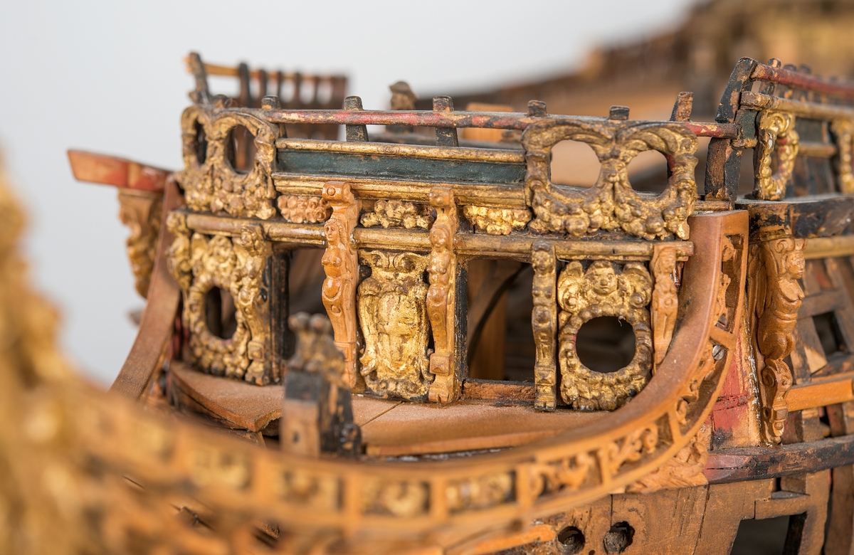 This unplanked model of a three-decker can be dated to c. 1660 and is one of the world's oldest models of a warship. Although not definitively identified, recent research links it to the Swedish ship *Riksäpplet*, designed by the English master shipwright Francis Sheldon and launched in 1661.     
The model was possibly made for Sheldon, who came to Sweden in 1659. He was one of a number of English shipwrights employed by the Swedish crown during the period. Previously, most Swedish warships had been built in the Dutch style.

From around 1660, the English Royal Navy’s administrators commissioned models that were accurately detailed and true to scale. These miniatures, which came to be called Navy or Admiralty Board models, had an unplanked lower hull to emphasise the shape of the underwater body. 

The model was restored by rear-admiral Jacob Hägg in the late 1890s. Missing parts have been reconstructed using lighter coloured wood.

3D model produced by Adam de Kaminski and Vasilis Haroupas for SMTM, 2023
