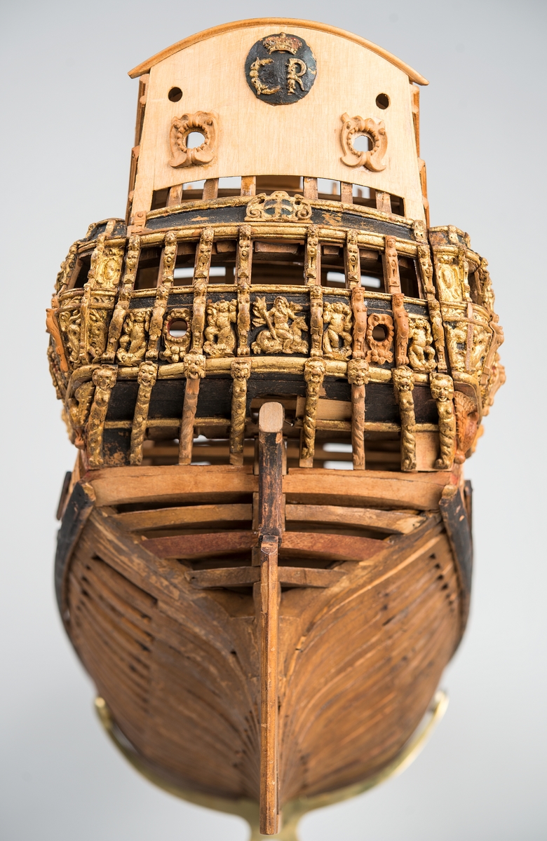 This unplanked model of a three-decker can be dated to c. 1660 and is one of the world's oldest models of a warship. Although not definitively identified, recent research links it to the Swedish ship *Riksäpplet*, designed by the English master shipwright Francis Sheldon and launched in 1661.     
The model was possibly made for Sheldon, who came to Sweden in 1659. He was one of a number of English shipwrights employed by the Swedish crown during the period. Previously, most Swedish warships had been built in the Dutch style.

From around 1660, the English Royal Navy’s administrators commissioned models that were accurately detailed and true to scale. These miniatures, which came to be called Navy or Admiralty Board models, had an unplanked lower hull to emphasise the shape of the underwater body. 

The model was restored by rear-admiral Jacob Hägg in the late 1890s. Missing parts have been reconstructed using lighter coloured wood.

3D model produced by Adam de Kaminski and Vasilis Haroupas for SMTM, 2023
