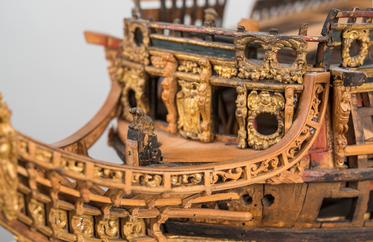 This unplanked model of a three-decker can be dated to c. 1660 and is one of the world's oldest models of a warship. Although not definitively identified, recent research links it to the Swedish ship *Riksäpplet*, designed by the English master shipwright Francis Sheldon and launched in 1661.     
The model was possibly made for Sheldon, who came to Sweden in 1659. He was one of a number of English shipwrights employed by the Swedish crown during the period. Previously, most Swedish warships had been built in the Dutch style.

From around 1660, the English Royal Navy’s administrators commissioned models that were accurately detailed and true to scale. These miniatures, which came to be called Navy or Admiralty Board models, had an unplanked lower hull to emphasise the shape of the underwater body. 

The model was restored by rear-admiral Jacob Hägg in the late 1890s. Missing parts have been reconstructed using lighter coloured wood.

3D model produced by Adam de Kaminski and Vasilis Haroupas for SMTM, 2023
