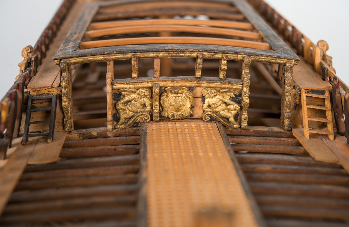 This unplanked model of a three-decker can be dated to c. 1660 and is one of the world's oldest models of a warship. Although not definitively identified, recent research links it to the Swedish ship *Riksäpplet*, designed by the English master shipwright Francis Sheldon and launched in 1661.     
The model was possibly made for Sheldon, who came to Sweden in 1659. He was one of a number of English shipwrights employed by the Swedish crown during the period. Previously, most Swedish warships had been built in the Dutch style.

From around 1660, the English Royal Navy’s administrators commissioned models that were accurately detailed and true to scale. These miniatures, which came to be called Navy or Admiralty Board models, had an unplanked lower hull to emphasise the shape of the underwater body. 

The model was restored by rear-admiral Jacob Hägg in the late 1890s. Missing parts have been reconstructed using lighter coloured wood.

3D model produced by Adam de Kaminski and Vasilis Haroupas for SMTM, 2023
