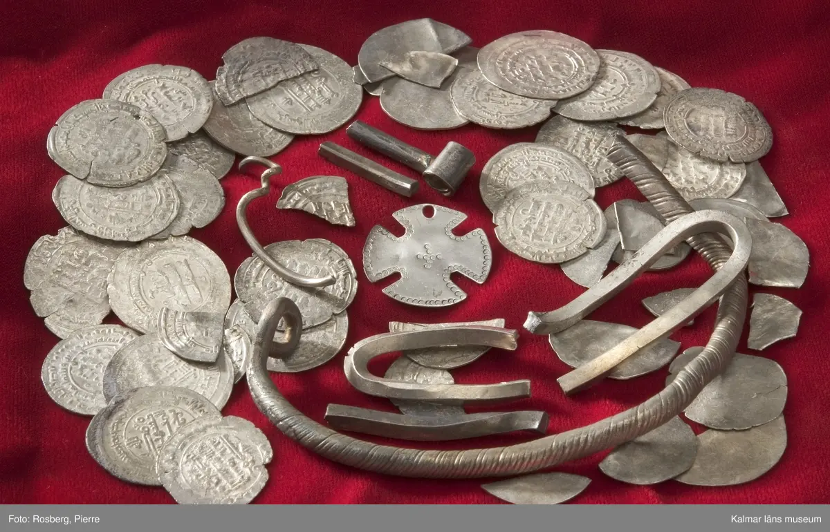 KLM 23964. Skattfynd, av silver. 1111 st mynt, 1 st hängkors, 35 st runda plantsar (varav 16 fragment), 7 st fragment av smycken (hacksilver).