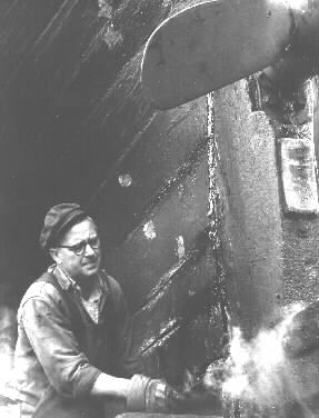 Timmerman Sven "Lille-Sven" i arbete vid slipen (fiskebåtsslipen). Fiskebåten är FG 8.  