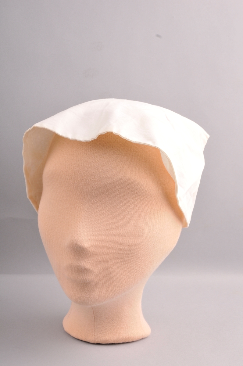 Lerretshette sydd med maskin og for hand. Strikk og rynka midt bak. Eit knapphol på kvar side med knapp slik at hetta blir knept saman bak. Hetta er laga i eit stykke. Dobbelt tøy. Avrunda framme. Lapp med talet to i nakken.