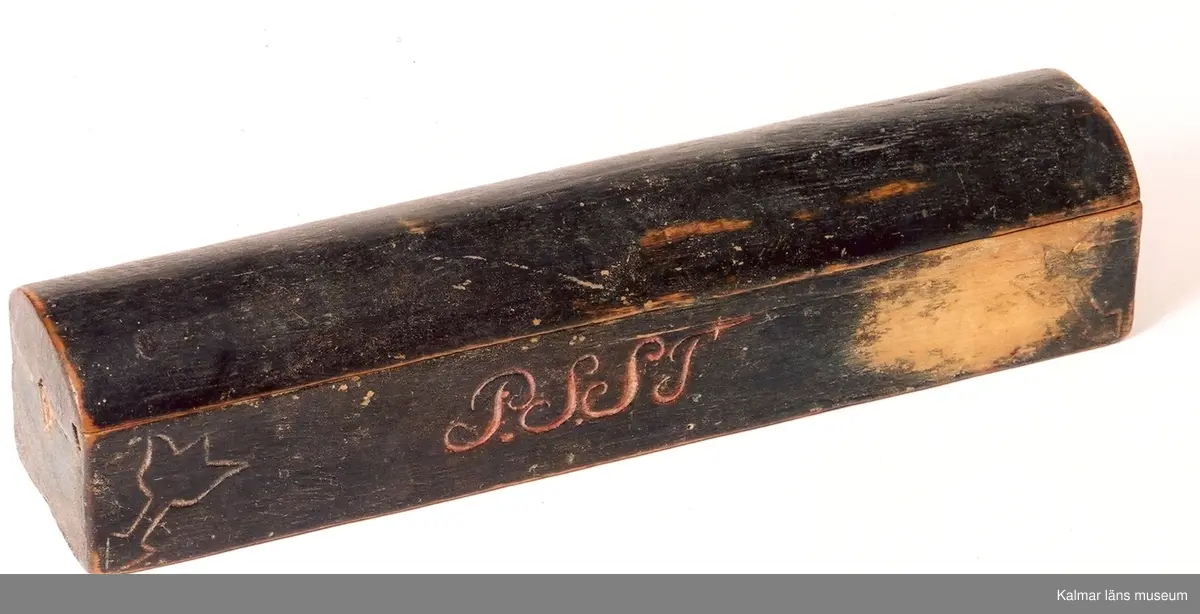 KLM 6600. Raklåda av trä. Avlång med kullrigt lock. Inuti ett särskilt rum för tvål. På ena sidan: P.S.S.T. På den andra: 1803. Tulpanmotiv i fyra hörn. Skadad i botten. Svartmålad.