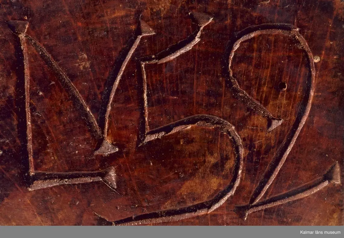 KLM 6626. Raklåda av björk. Raklådan skuren ur ett stycke. Skjutlock av bok. Lock och långsidor ornerade med karvsnittsrosetter och virvelhjul. På ena gaveln inskuret ANO 1781, på den andra ett LN 52, (LN ihopskriver). I bottens undersida inslagna mässingsstift bildande initialerna LN. Lådan fernissad i senare tid.