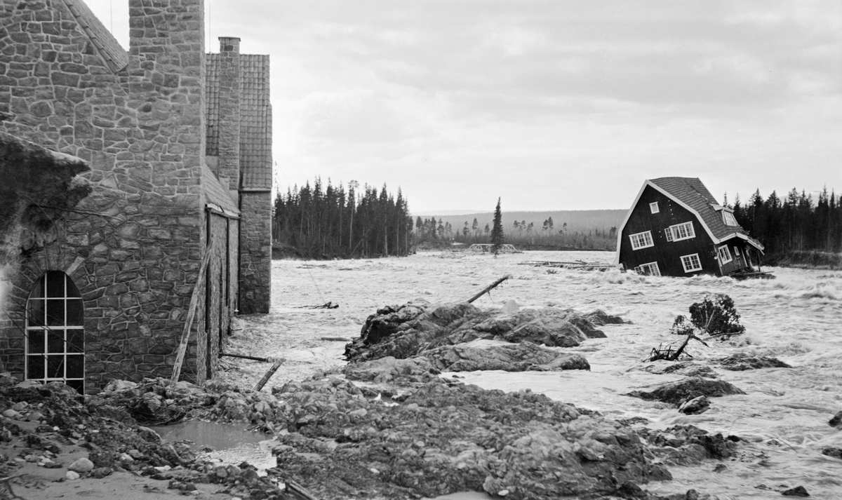 Fra det store dambruddet ved Osfallet i elva Søndre Osa i Åmot kommune i Hedmark våren 1916.  Til venstre i bildet ser vi det nordre hjørnet av kraftstasjonen, nærmere bestemt maskinsalen, der det sto to turbiner som hver kunne yte 1 800 hestekrefter.  Bygningen er sannsynligvis en støpt betongkonstruksjon som utvendig er forblendet med natursteinsmur.  Den hadde et bratt tak som var tekket med krumtegl, og vinduene i maskinsalen var bygd rundt støpejernsrammer med et visst spissbuet, gotisk preg.  Da dette fotografiet ble tatt sto det vann og grus langt oppover veggene på kraftverksbygningen.  Enda verre hadde det gått med maskinistboligen, en toetasjes trevilla med mansardtak, som opprinnelig sto i skråningen nord for det opprinnelige elveløpet.  Lengre nede i vassdraget, sentralt i bildet, skimter vi også ei fagverksbru av stål, som vannmassene åpenbart har revet løs fra de brukara den opprinnelig kvilte på, slik at den ble liggende i elveleiet.

Mer informasjon om kraftutbygginga ved Osfallet og det store dambruddet som inntraff i 1916 finnes under fanen «Opplysninger».