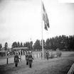 Inmarsch på Rocksjövallen. Svenska Flaggans Dag. Flaggan hissas.