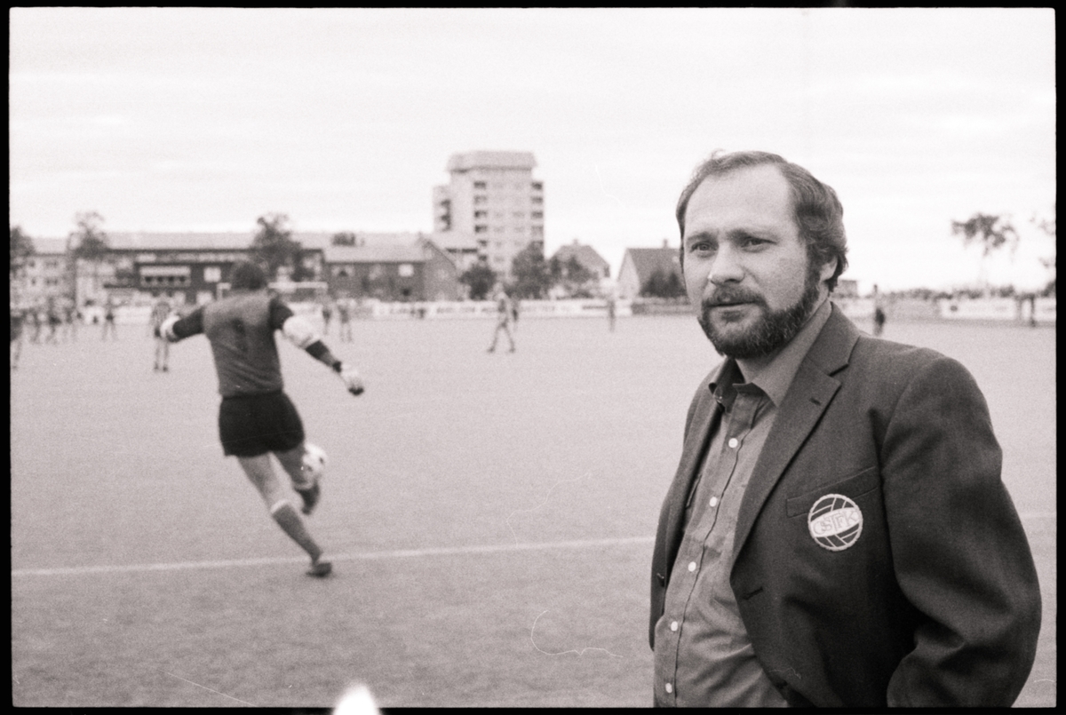 Egil Elvevoll på Harstad stadion. Fotballspillere i bakgrunnen.