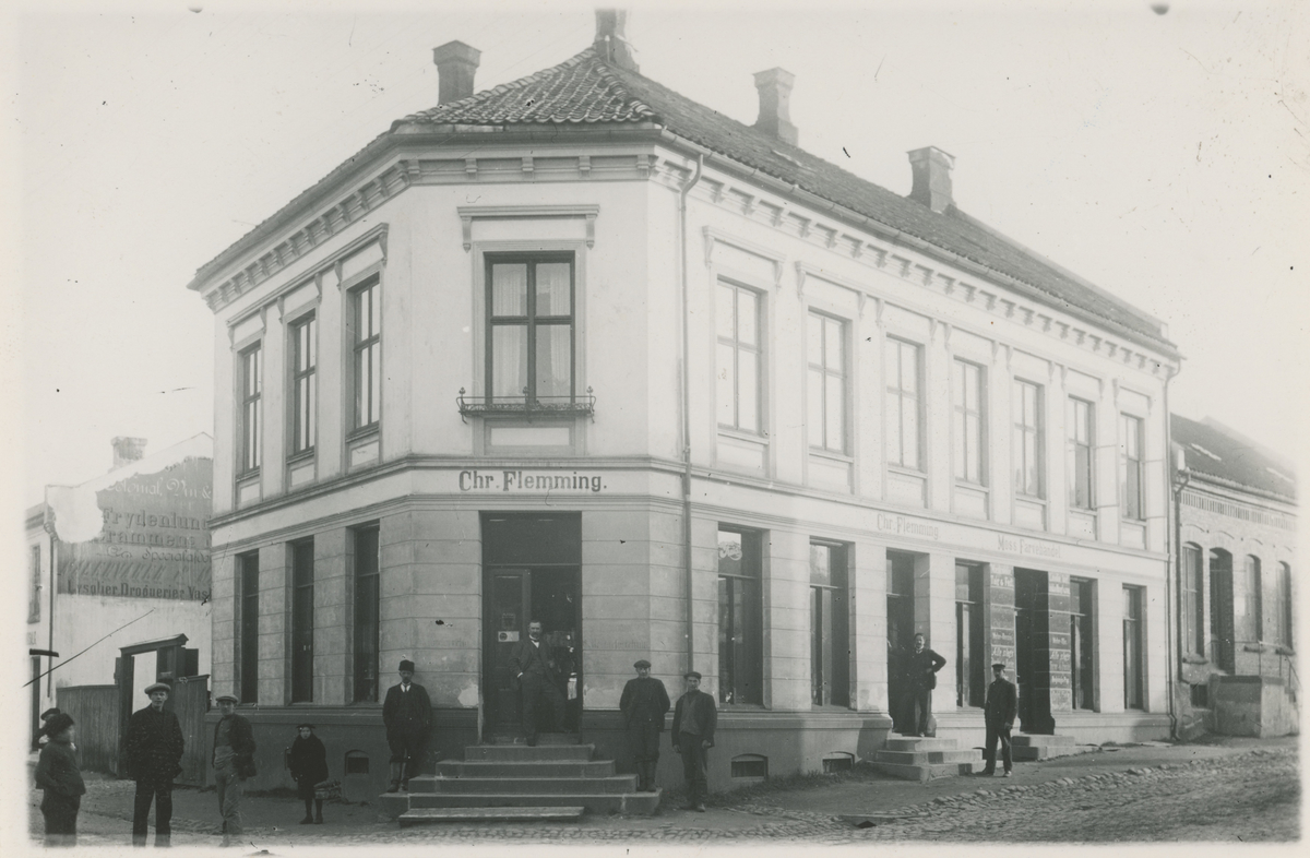 Ca. 1910.

Bilde 1:
Fotograf har stått i front for butikken.
Detaljer:	Dronningens gate 17, L. P. Sterud med ansatte.
Historikk: Sterud åpnet 1. april 1895 og var aktive helt opp til våre dager.				

Bilde 2:
Fotograf har stått i front for bygningen.	
Detaljer:	Kongens gate 5 med folk i vinduene.
Historikk: Kongens gate 5 - Strømberggården. Oppført før 1798. Leilighetskompleks.

Bilde 3-4:
To kopier av samme bilde.
Fotograf har stått i front av bygningen.
Detaljer:	Kongens gate 9, Clemmentsgården. Skilt for Blikkenslager A. Larsen.
Historikk: Oppført før 1794. Brant ned i 1946. Denne delen av gata gikk under navnet "Konggata".

Bilde 5:
Fotograf har stått i krysset Vogts gate/Kongens gate. Flemmingkrysset i dag.
Detaljer:	Kongens gate 44, forretningen til Christian Flemming.
Historikk: Opprettet i 1891. Overtok lokalene etter Chr. Hermanstorffs kolonial. Butikken flyttet til Kongens gate 38 i 1941 med ny eier.

Bilde 6:
Fotograf har stått i Kongens gate.
Detaljer:	Kongensgate 1. S. Jensen Kolonial, med ansatte. Folk, Storebro i bakgrunnen.
Historikk: Denne delen gikk under navnet Konggata og bygningen med navnet Thoresgården. Oppført på slutten av 1700. Brant ned i 1981.

Bilde 7:
Fotograf har stått på utsiden av bygningen.
Detaljer:	Kongens gate 15, Café Central med ansatte, Rygge og Moss Herreds Lensmannskontor til venstre.
Historikk: Cafeen hadde telefonautomat.

Bilde 8:
Fotograf har stått ved Øvre torv.
Detaljer:	Kongens gate 24 (22 i dag). Reklame for Elefant-Apothek rundt hjørnet, A/S Moss Kaffeforretning med utstillingsvinduer.
Historikk: Elefantapoteket var i drift i perioden 1736 - ca. 2016. I Kongens gate 24 fra tidlig 1900.

Bilde 9:
Fotograf har stått i front av forretningen.
Detaljer:	Kongens gate 26. Anna Larsens Modeforretning med Anna Larsen og ansatte.
Historikk: Forretningen ble opprettet i 1897, og byttet adresse flere ganger.

Bilde 10:
Fotograf har stått rett utenfor forretningen.
Detaljer:	Kongens gate 14. Kjæmperud med ansatte, gasslykt.
Historikk: Byttet lokaler til Kongens gate 15 rundt 1913.