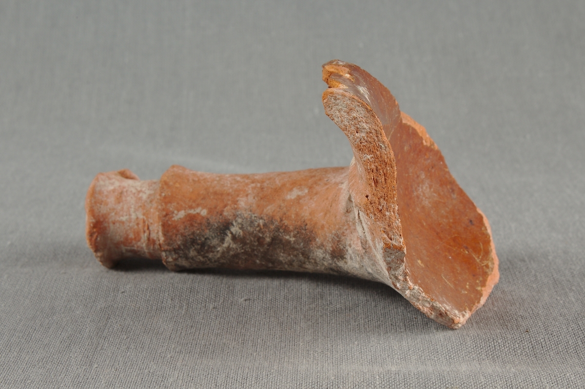 Handtag till kokkärl i lergods.
Glaserat fragment.