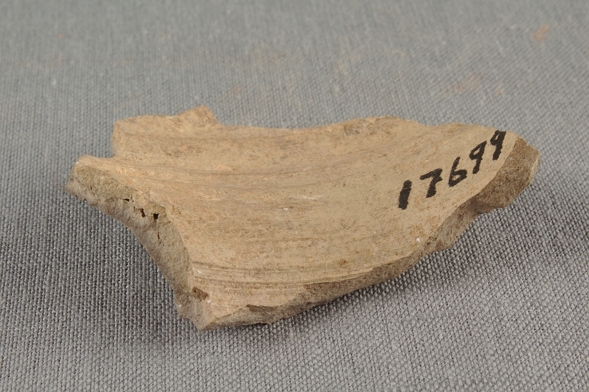 Fragment av drejat lerkärl.
Försett med en stjärnformad och instämplad dekor.