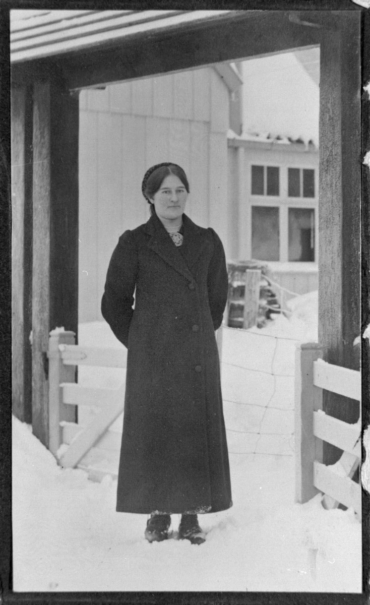 Mari Hansdotter Torstveit,  kvinne i vinterlandskap utanfor bygning