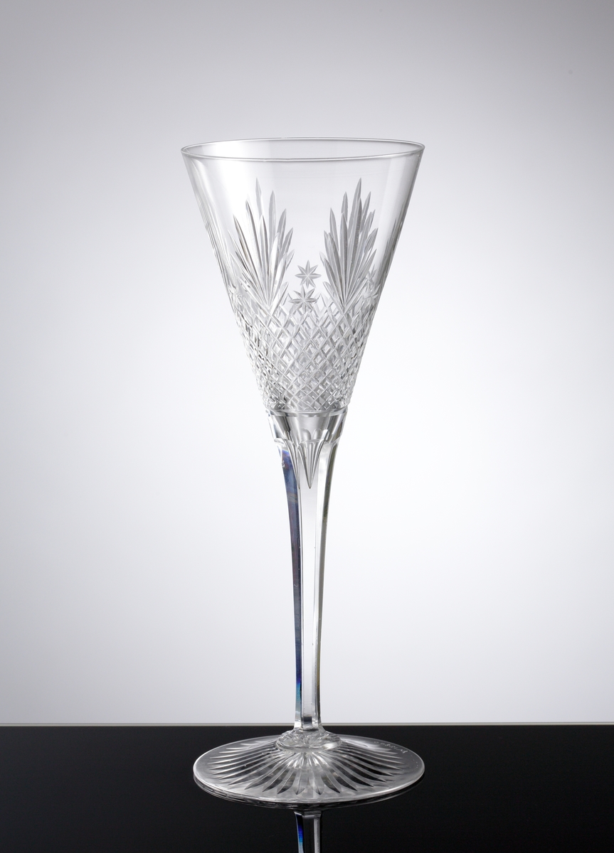 Champagneglas med slipade facetter, skär, rutor och stjärnor på kupan. Stjärnslipat under foten.