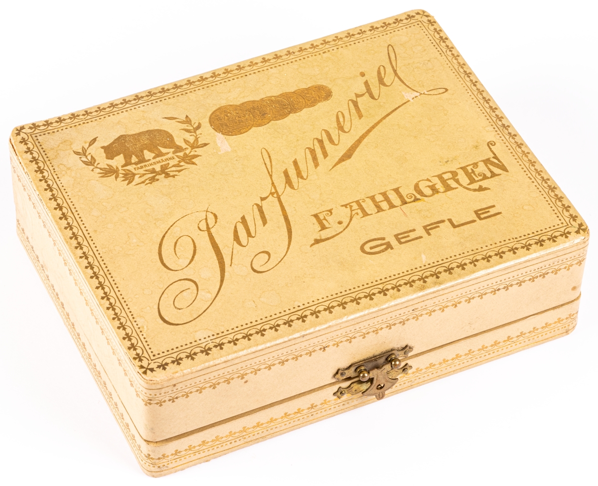 Etui med tre parfymflaskor.
På locket text i guld:
"Parfymeriet 
F. Ahlgren
Gefle"