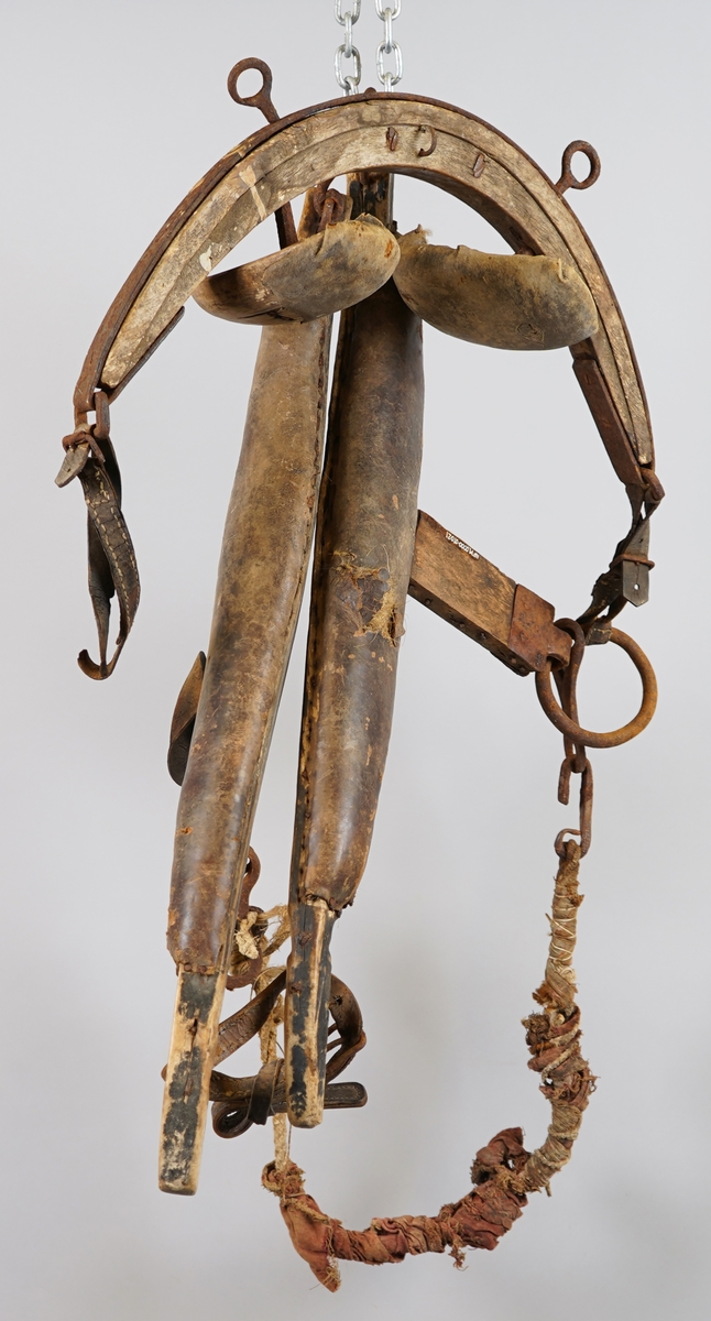 Seletøy til hest. Delar av arbeidssele: Bogtre i tre med polstra skinnputar (truleg polstra med grisebust). Drott (dragreim) av tre fest i bogtreet med jarn. Høvre av tre med jarn og puter av tre polstra med skinn. Tau polstra med tekstil, med jarnkrokar i kvar ende, er festa til ring i eine enda på dråttet.
Delane er hekta inn i kvarandre.