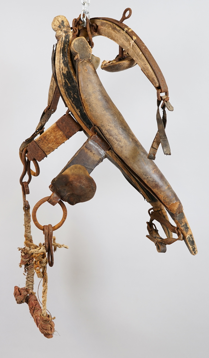 Seletøy til hest. Delar av arbeidssele: Bogtre i tre med polstra skinnputar (truleg polstra med grisebust). Drott (dragreim) av tre fest i bogtreet med jarn. Høvre av tre med jarn og puter av tre polstra med skinn. Tau polstra med tekstil, med jarnkrokar i kvar ende, er festa til ring i eine enda på dråttet.
Delane er hekta inn i kvarandre.