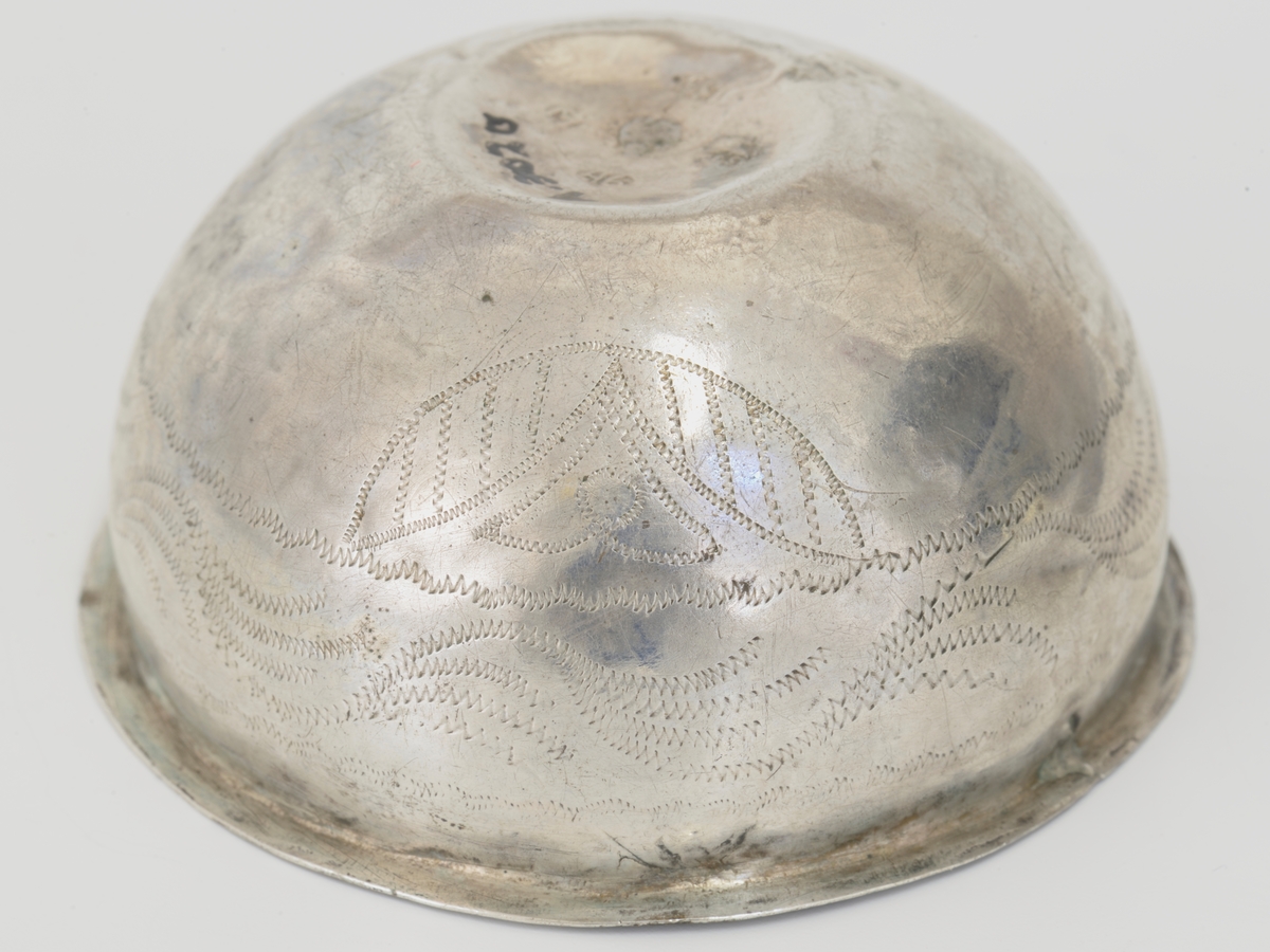 Sirkelformet bunn, sideprofilert. Bord av bølgende ranke, blader. Antagelig Bergensarbeide fra 1846