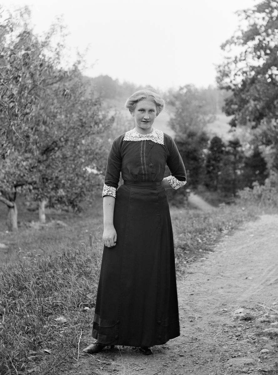 Agnes Jönsson från Vitudden på besök i fruktträdgården hos fotograf Emil Durling. Gift 1930 med Fredrik Valentin Fredriksson och tog tillsammans med sin make över torpet i Vitudden efter att hennes far gått bort senare samma år.