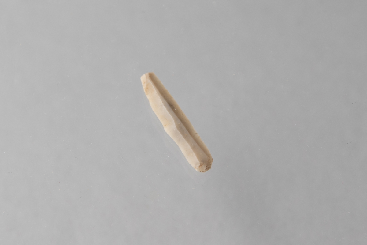 Mikrospån av flinta, proximal del, med slitspår.
