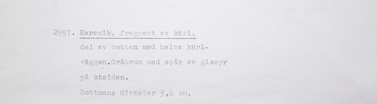 Halva botten till ett litet krus i sekundrbränt stengods. Bottendiameter ca 35 mm. Drejlinjer på insidan av kärlet.